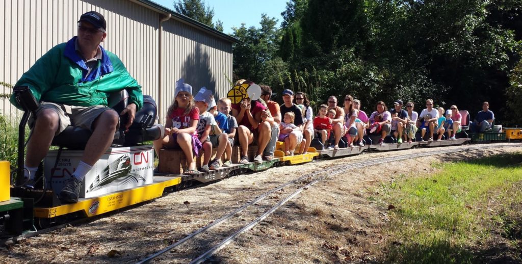 Families and children riding on miniature outdoor trains at the Milwaukee Light Engineering Society in Cedarburg.