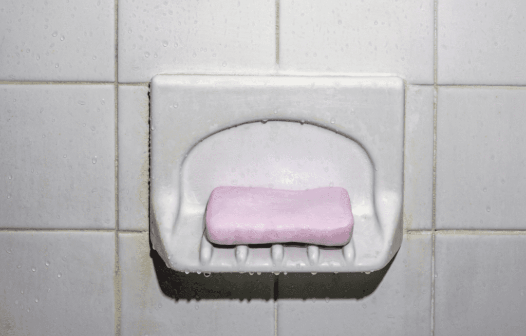 Pink bar of soap with white tile.