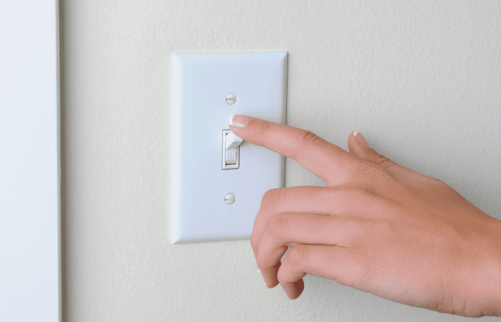 Person turning a light switch of or off.