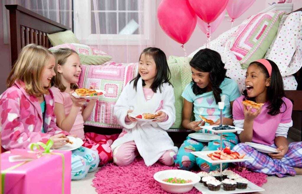 Girls eating pizza at a sleepover.