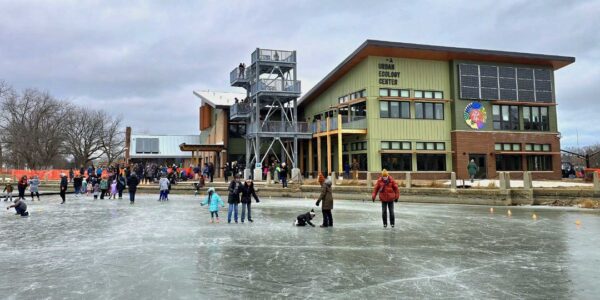 Kids playing on a frozen lake with a large building in the background