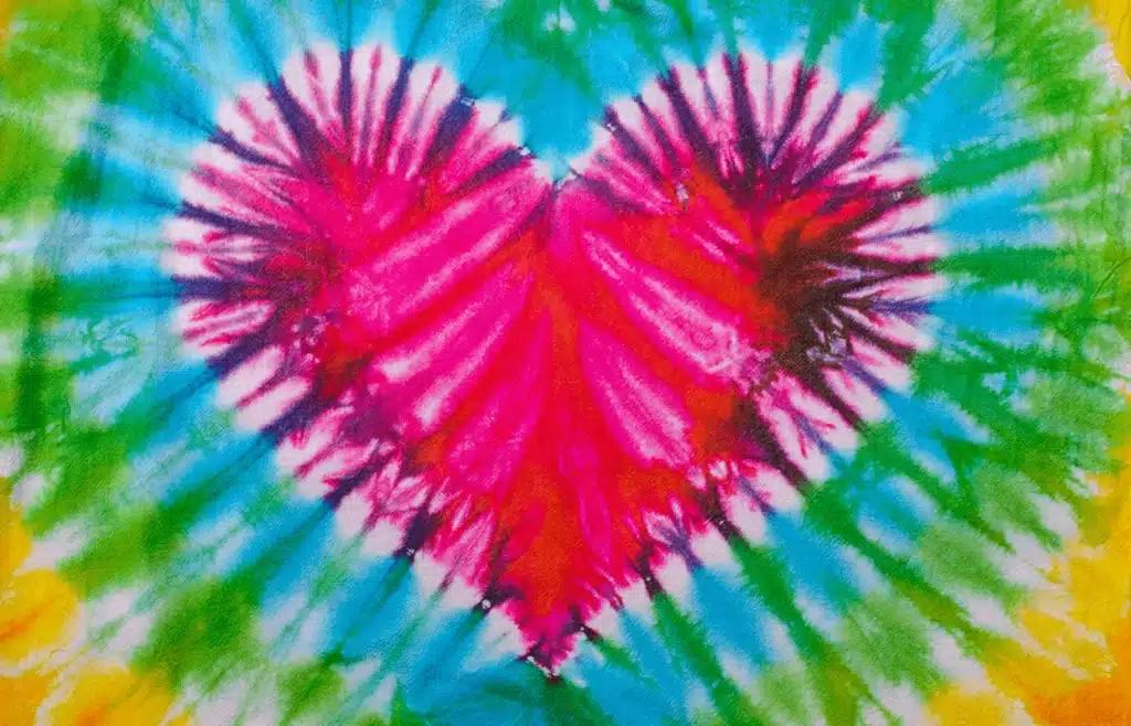 Colorful tie dye heart design on fabric with red, blue and green colors
