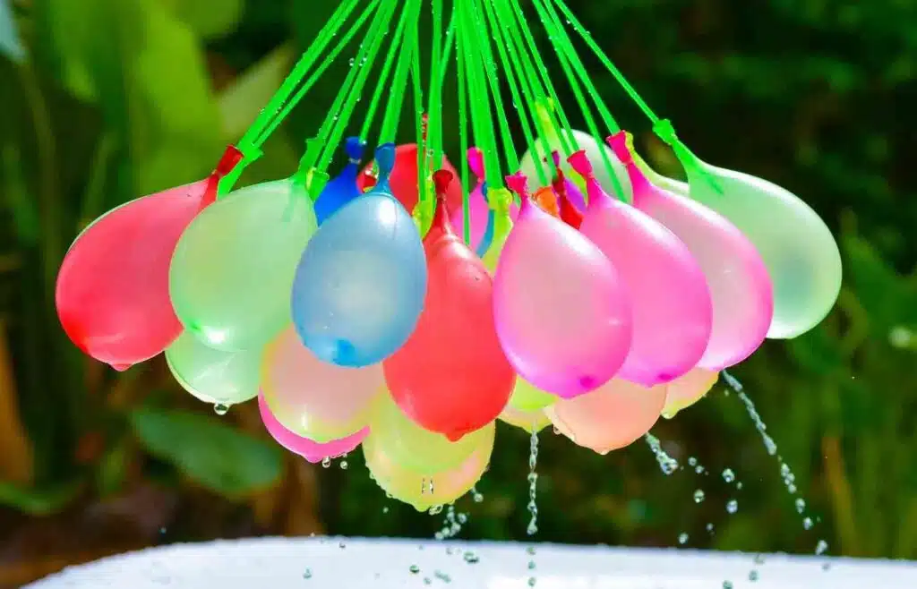 Colorful water balloons hanging and dripping with water