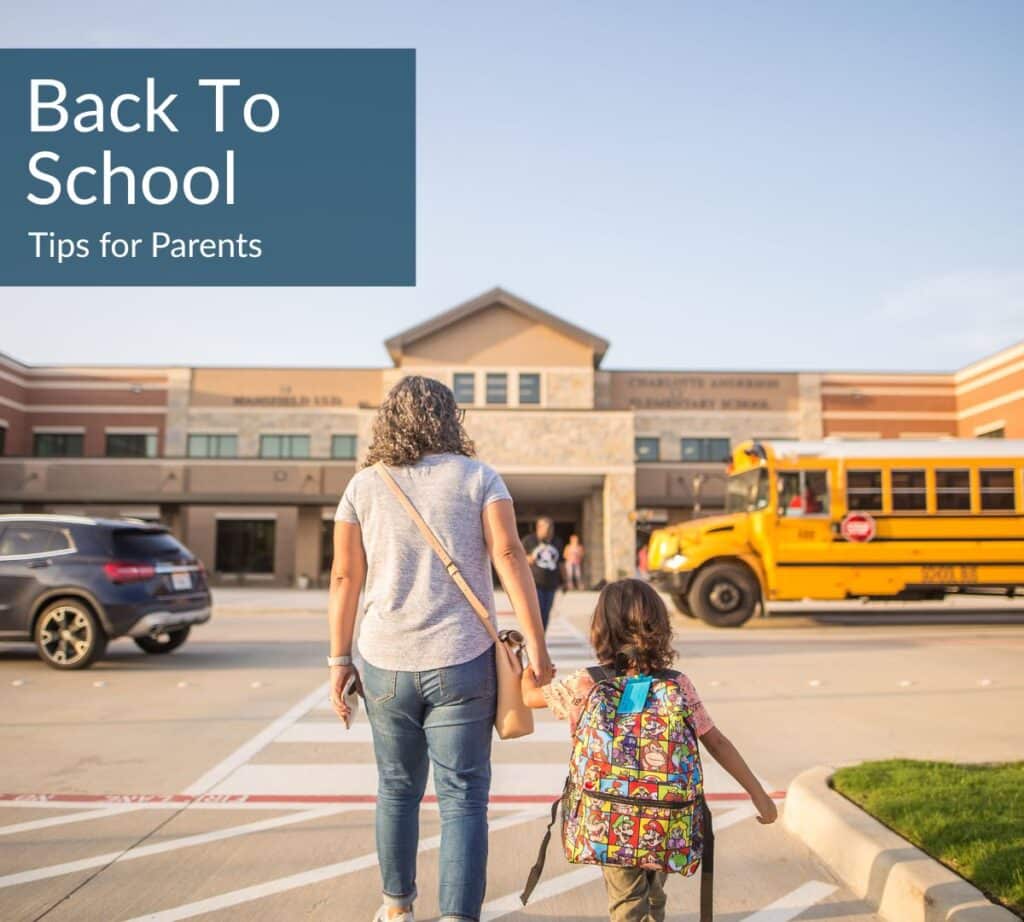 Parent and young child walking toward an elementary school building with a school bus parked outside. Text overlay reads “Back To School: Tips for Parents.”