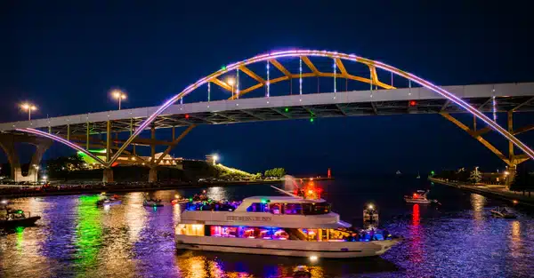 Boat cruising under the illuminated Hoan Bridge in Milwaukee at night
