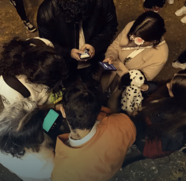 People gather around their smartphones to participate in a ghost hunt on a city street in Milwaukee.