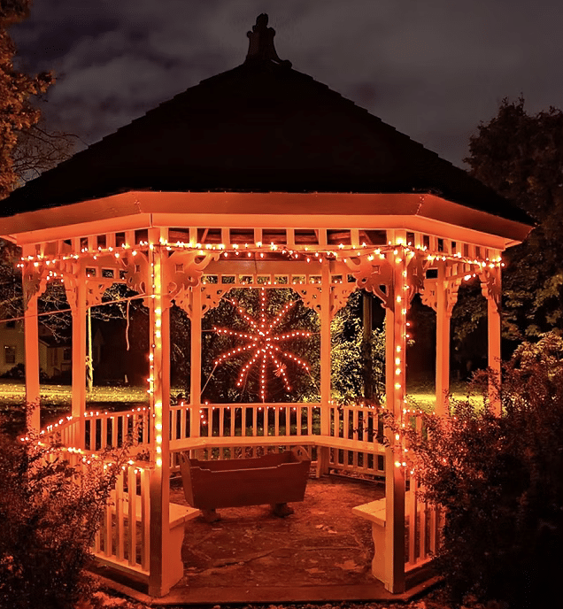 Pavilion in Menonomee Falls decorated with illuminated Halloween lights and a pretend orange spider.
