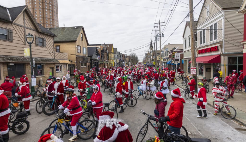 Hundreds of people dressed in Santa costumes ride their bikes through the East Side of Milwaukee for the Santa's Rampage event.