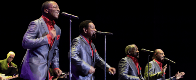 Four men in Motown suits sing on stage at A Motown Christmas.