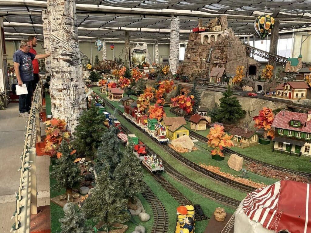 G-scale model trains running through detailed miniature scenery inside Shady Lane Greenhouse in Menomonee Falls, Wisconsin.