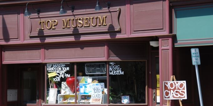 The storefront of the Spinning Top & Yo-Yo Museum in Burlington, with signs advertising yo-yo classes and hands-on exhibits.