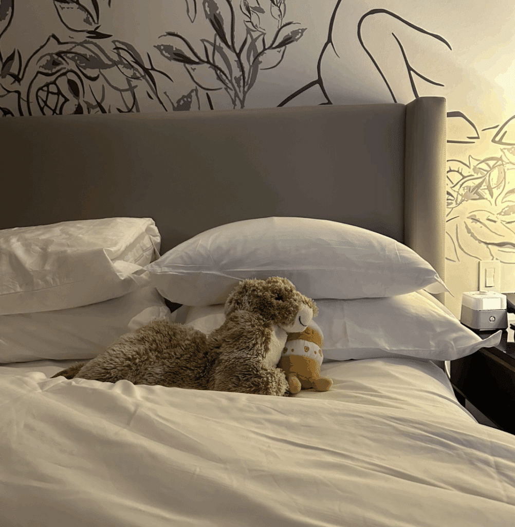 Hotel bed at The Gwen Chicago with plush stuffed animals neatly tucked in after evening turndown service.