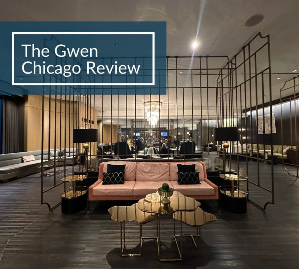 Elegant lobby at The Gwen Chicago with blush pink sofa, gold accent tables, and art-deco inspired lighting and decor.