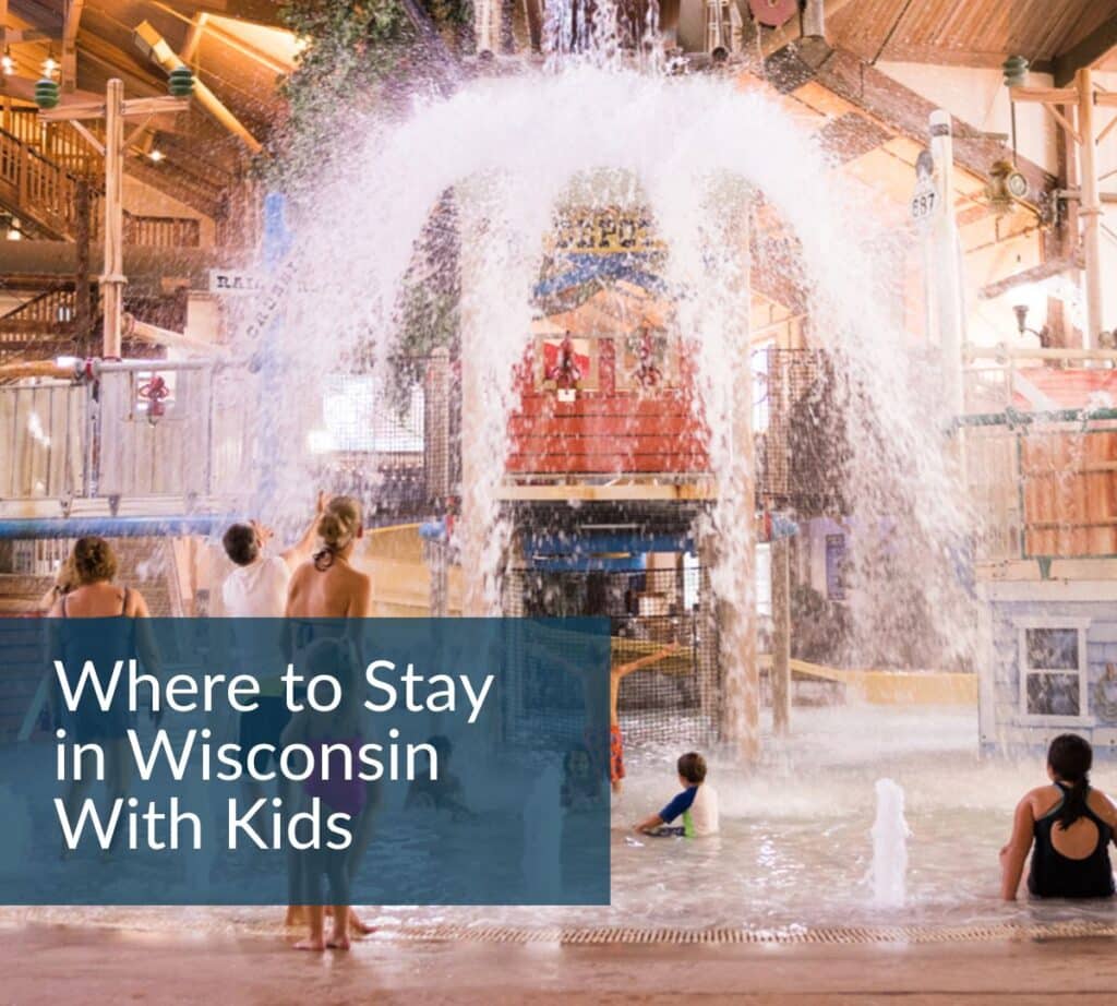 Guests stand in shallow water as a giant bucket dumps water over them inside a rustic, lodge-style indoor Springs Water Park in Pewaukee Wisconsin.