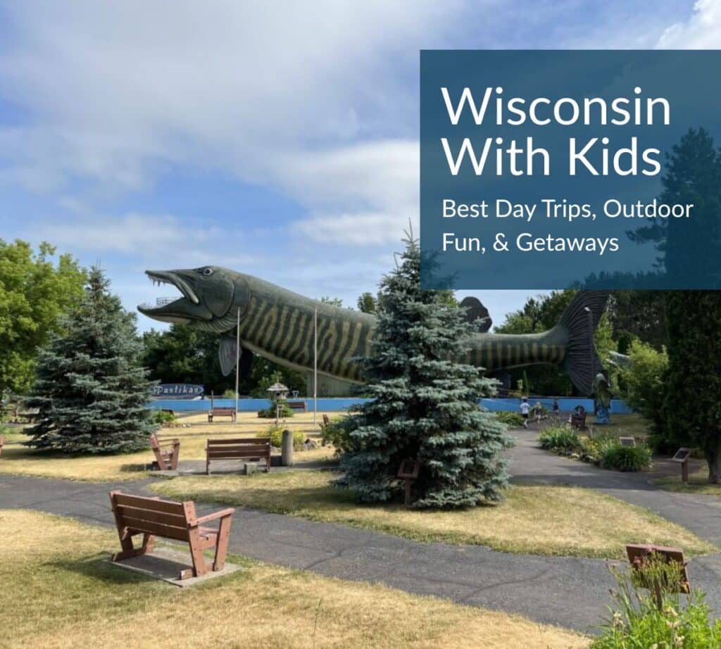 World’s largest muskie sculpture at the National Fresh Water Fishing Hall of Fame in Hayward, Wisconsin, with benches and trees in the foreground — featured image for “Wisconsin With Kids: Best Day Trips, Outdoor Fun & Getaways” blog post.