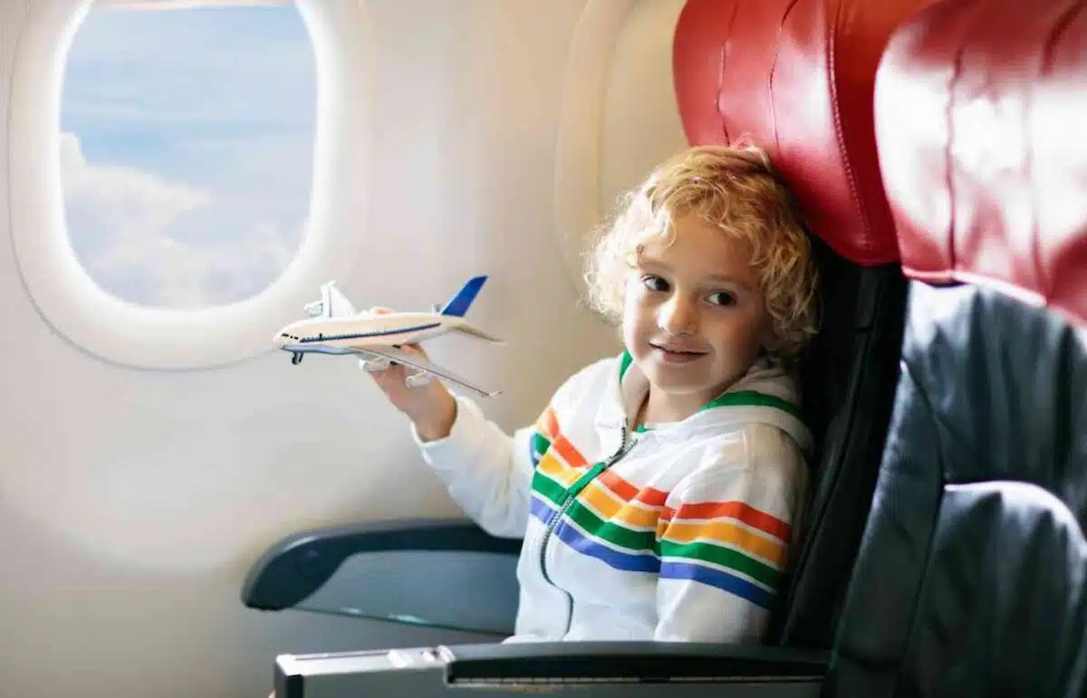 Toddler using window clings on an airplane window.
