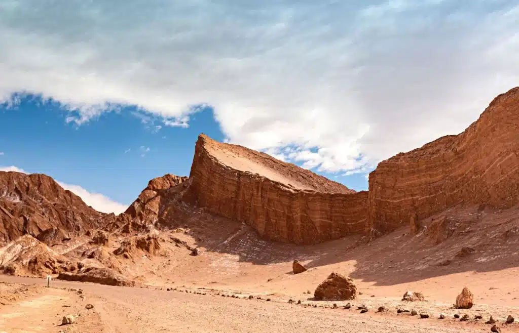 Desert landscape wiith dramatic rock formnations with blue sky and white clouds.