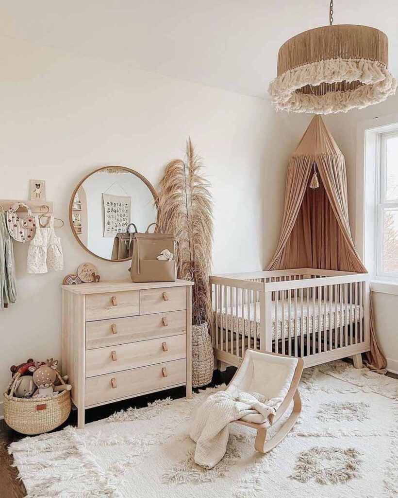 Baby girl nursery featuring natural wood furniture, pampas grass, and warm earthy tones with a boho canopy.