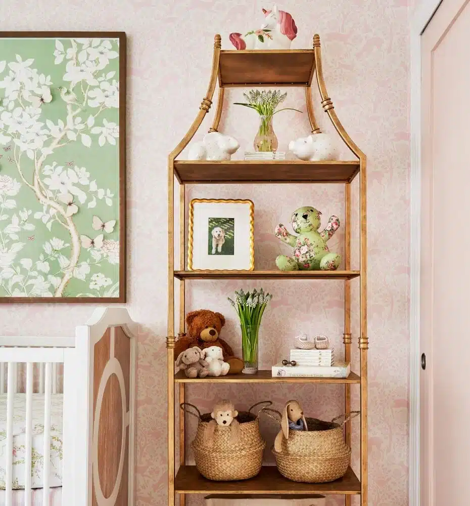 Baby girl nursery featuring floral wallpaper, a vintage wooden bookcase, and timeless decor representing the sustainability and heirloom trend for 2026.