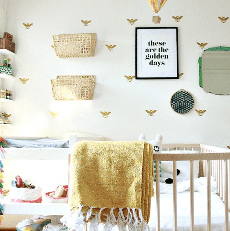 Baby girl nursery with bee print wall paper, floating cabiets and jute wall baskets inspired by bumble bees