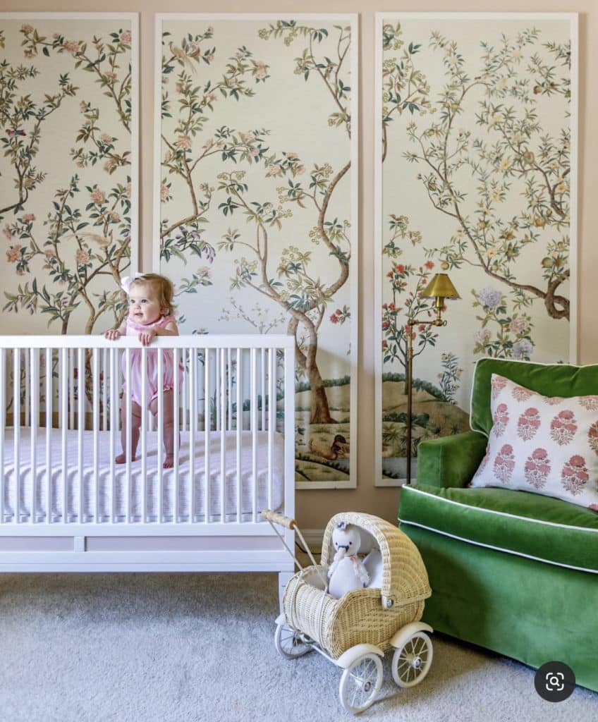 Baby girl nursery with tall stand lamp, retro style white crib, wooden floors , raffia floor baskets and antqie style floral wallpaper representing vintage roses.
