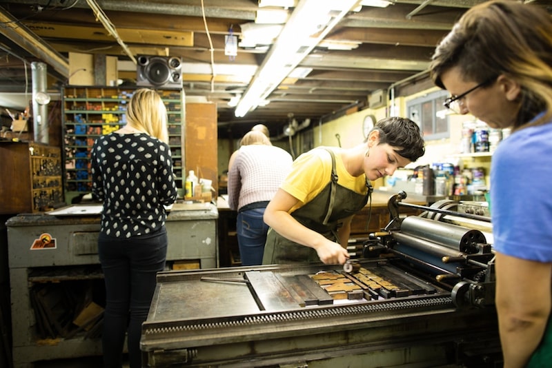 Participants working in the basement letterpress studio at Bay View Printing Co., arranging type and preparing prints.