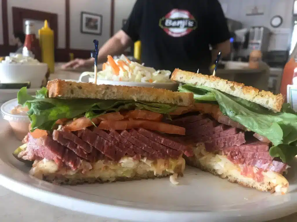 A giant deli sandwich with ham and lettuce and salad on the side at Benji's Deli in Shorewood