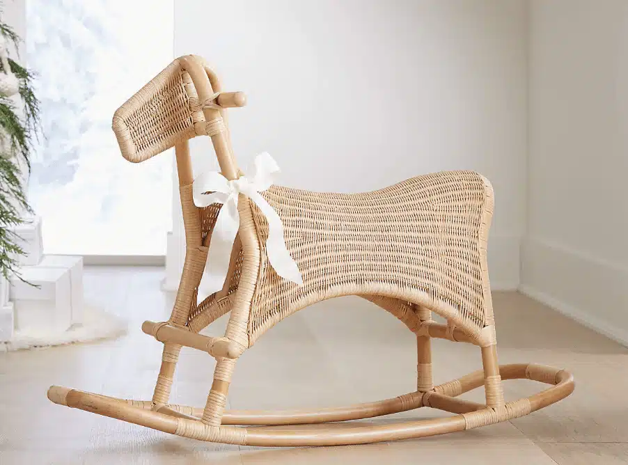 A rocker entirely made of rattan with a white bow 