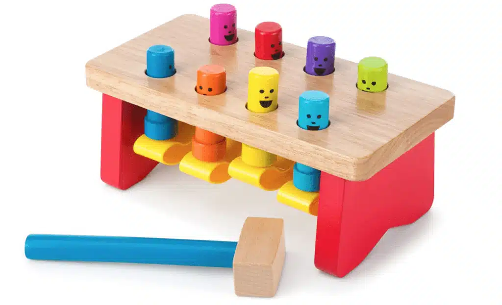 A toy pounding bench with colorful pegs and a wooden mallet with blue handle