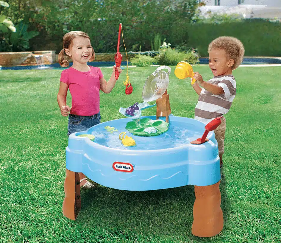 Two kids playing fishing on a blue Little Tikes splash water table in the lawn