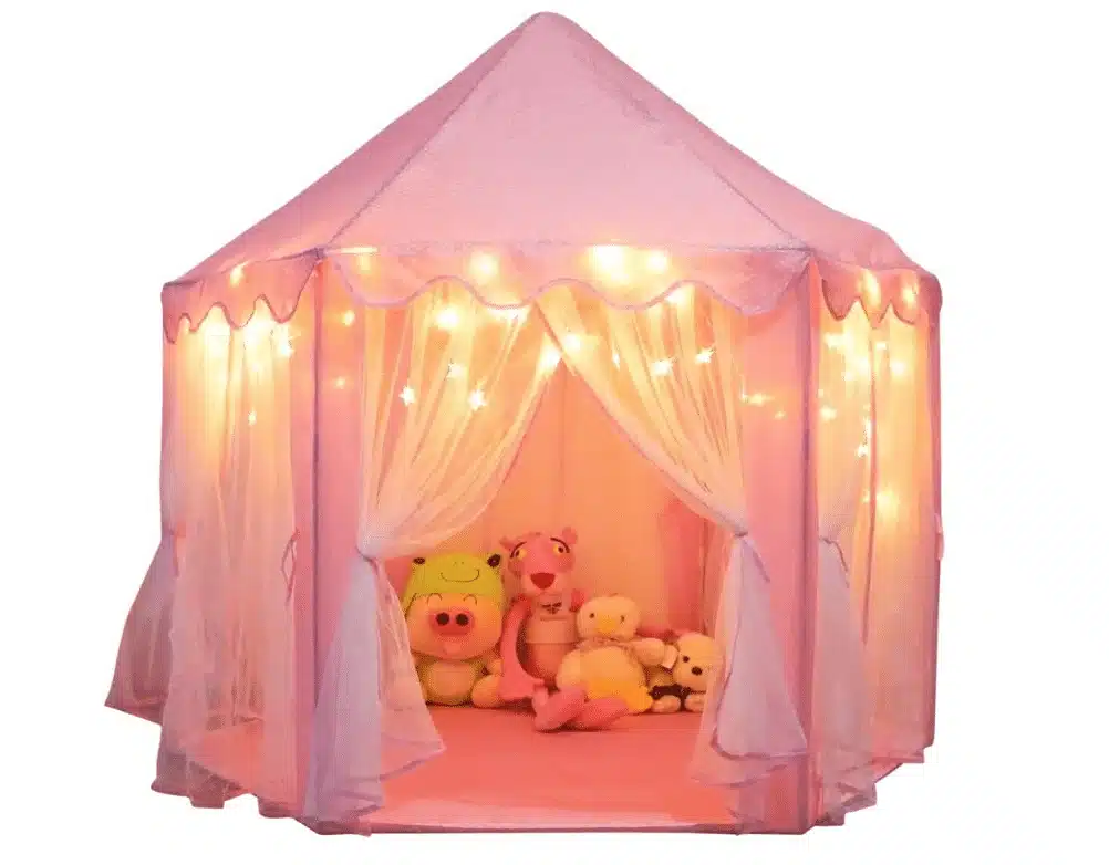 A pink playhouse pen with fairy lights and some plushies inside