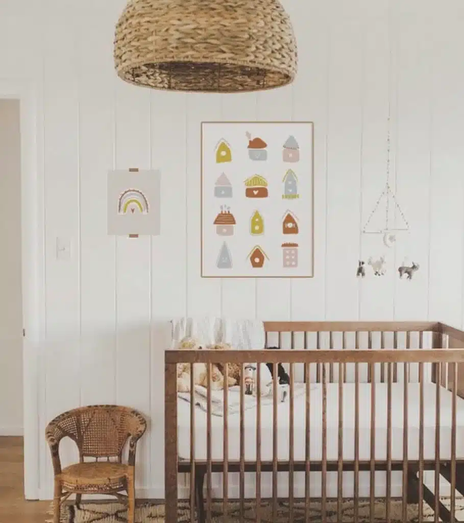 Birdhouse-inspired gender-neutral nursery with illustrated home style wall decor and vintage rattan chair