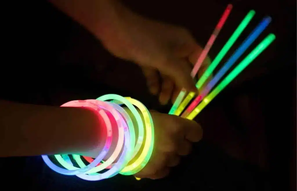 Kids wearing and holding glow sticks at a birthday dance party