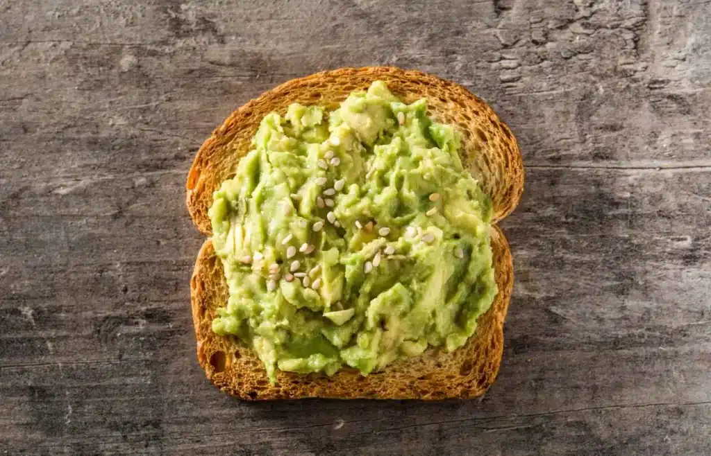 Creamy mashed avocado on whole-grain toast topped with sesame seeds.
