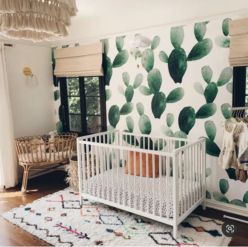 Cactus gender-neutral nursery with green wallpaper and minimalist crib