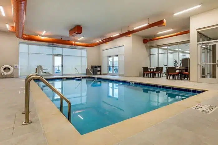 Indoor pool at the Cambria Hotel Milwaukee, featuring a modern design with sleek flooring and bright lighting