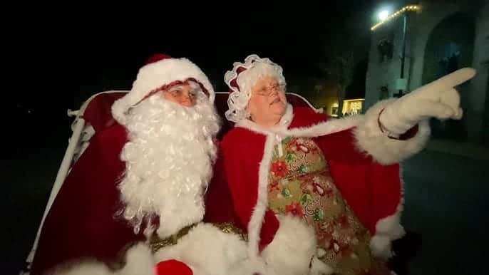 Mrs and Santa Claus riding their sleigh on their way to the Cedarburg Christmas Tree Lighting celebration.