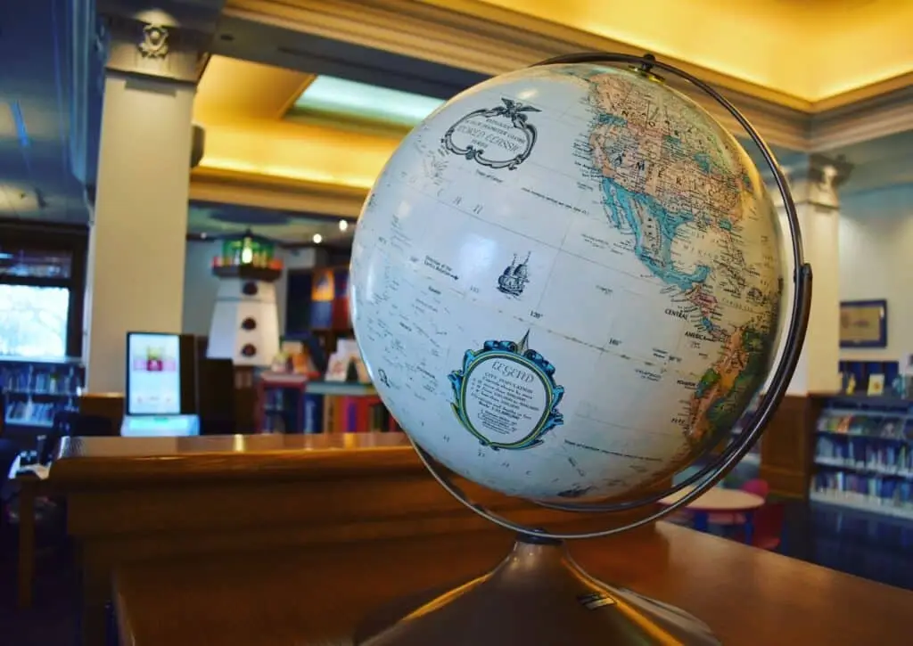 A close-up view of a globe on a table inside a library
