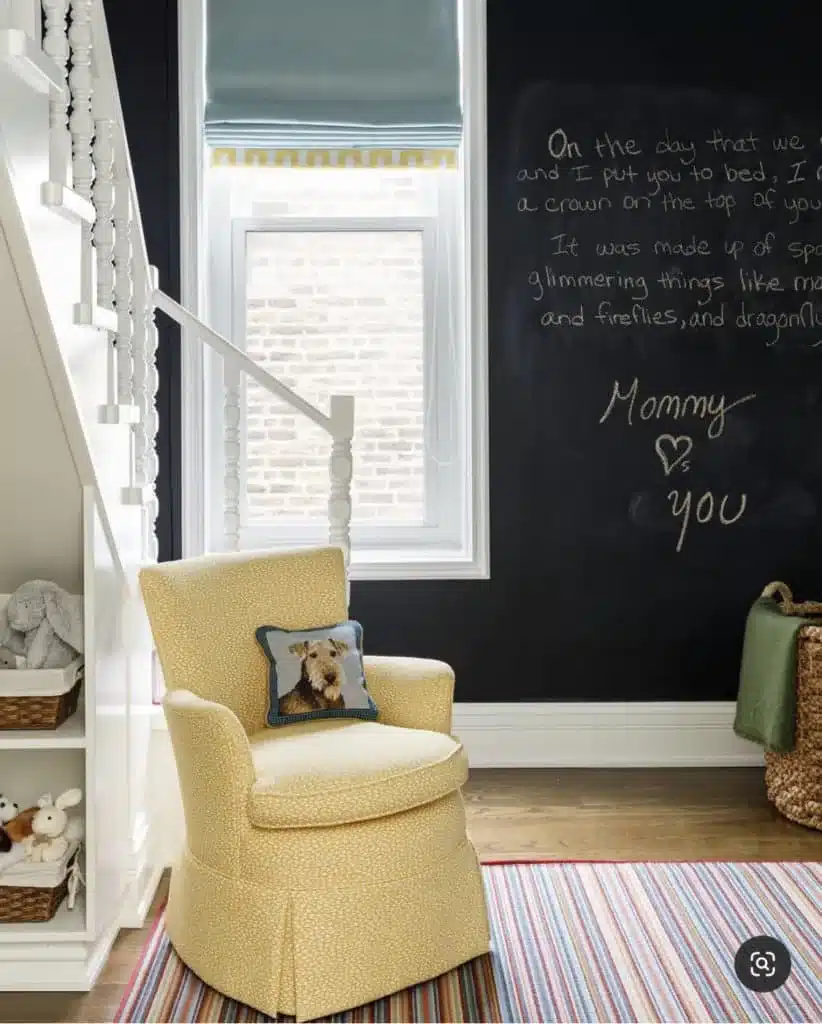 Chalkboard gender-neutral nursery with handwritten wall quote and yellow chair