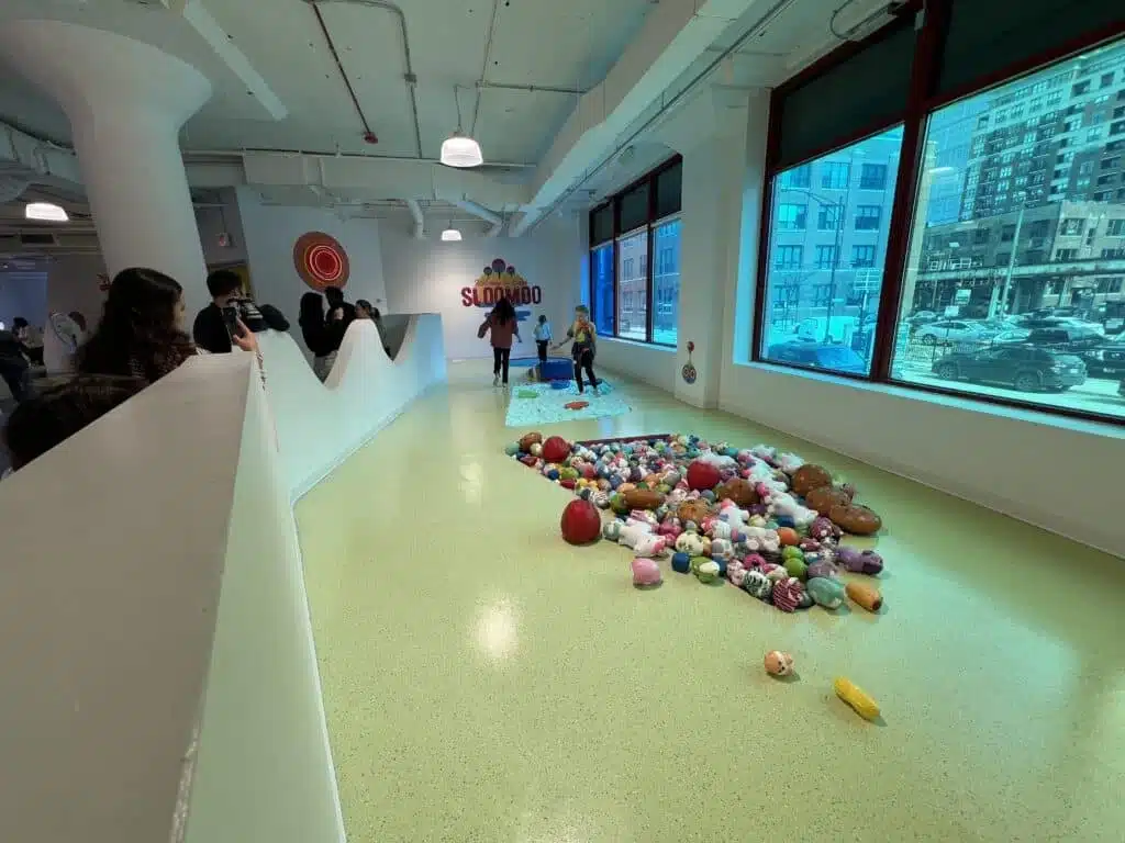 Kids explore the slime obstacle course at Sloomoo Institute Chicago, walking through sensory slime stations.