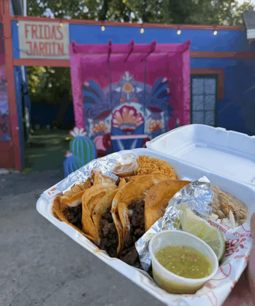 A serving of tacos with green salsa with lime in front of Chucho's Red Tacos in Milwaukee