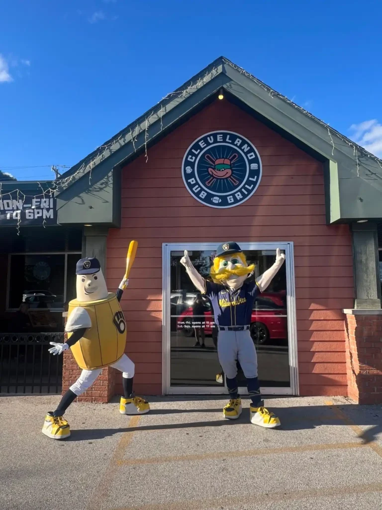 Two maskots posing in front the Cleveland Pub and Grill in New Berlin