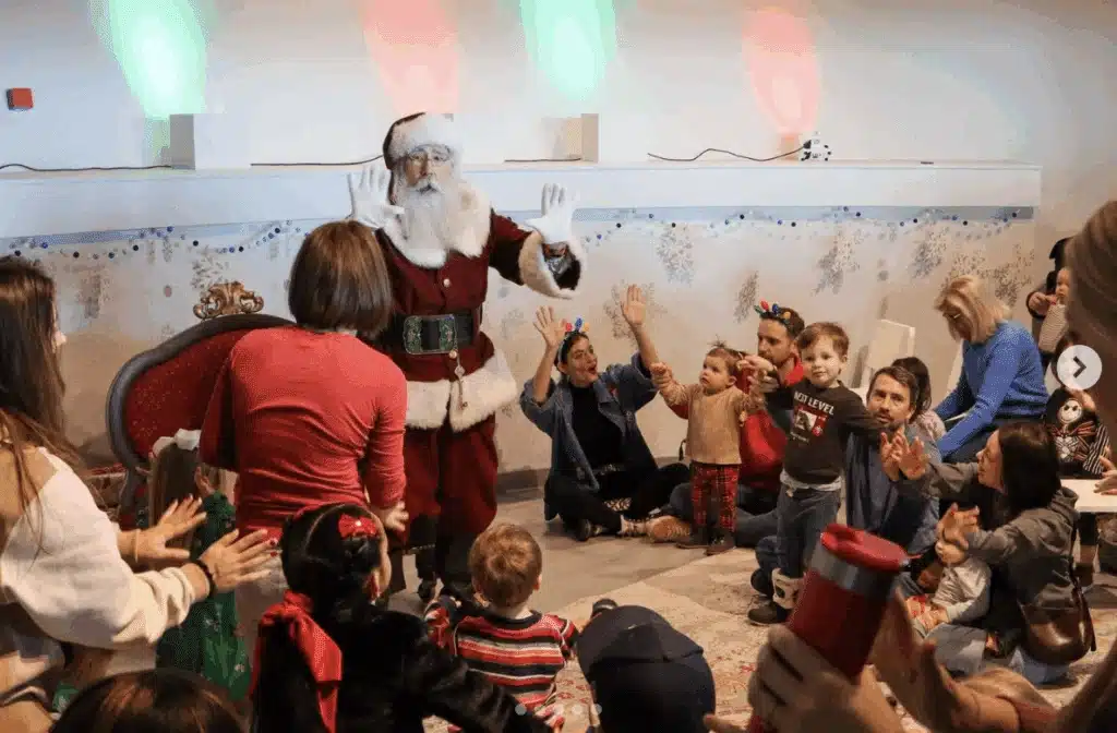 Santa playing games with children at the Cocoa and Clause at Betty Brinn Museum