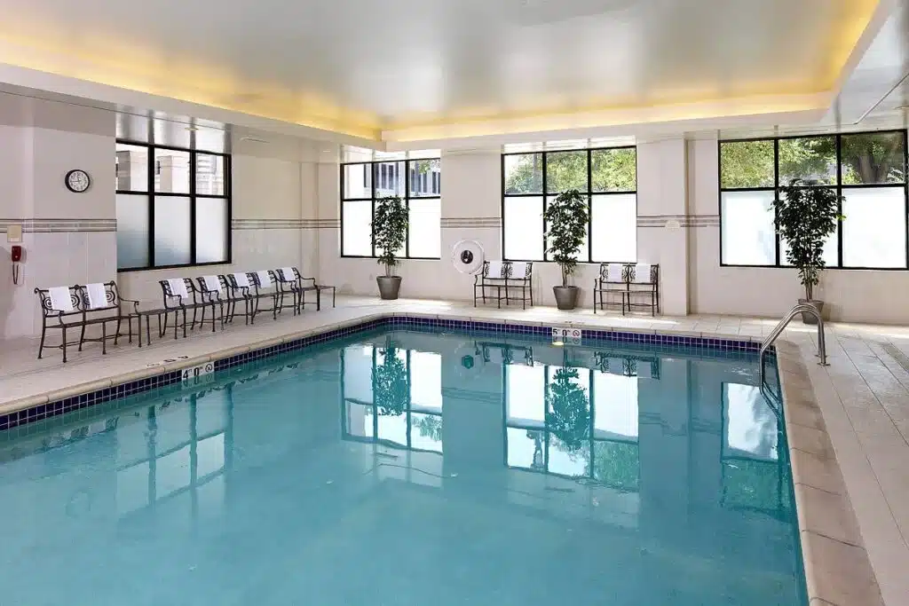The calm pool of Courtyard by Marriott in downtown Milwaukee with potted plants and steel benches