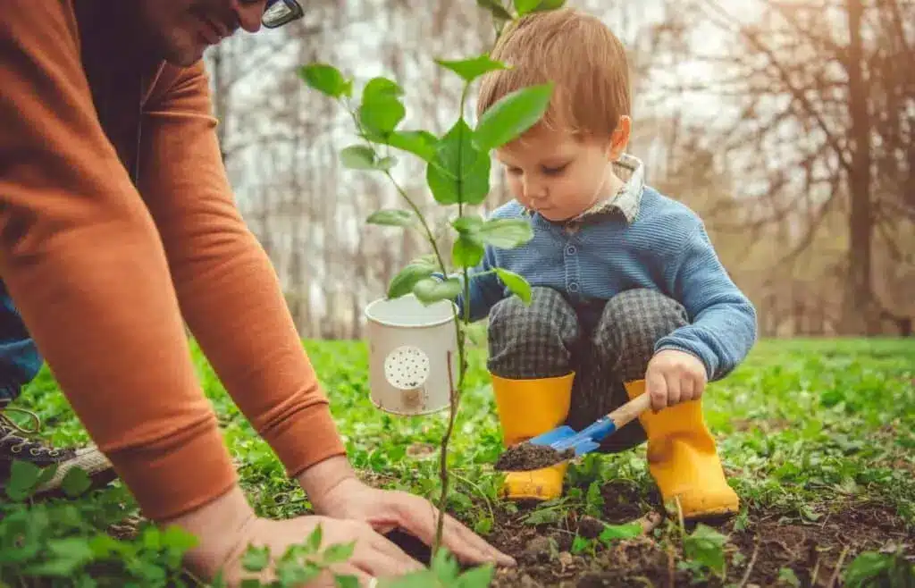 Father and son gardening and watering a plant