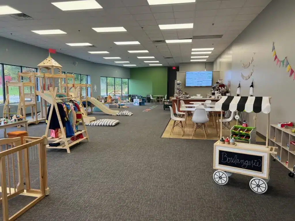 Wide view of Bug & Goose Delafield play space with imaginative stations and café seating.