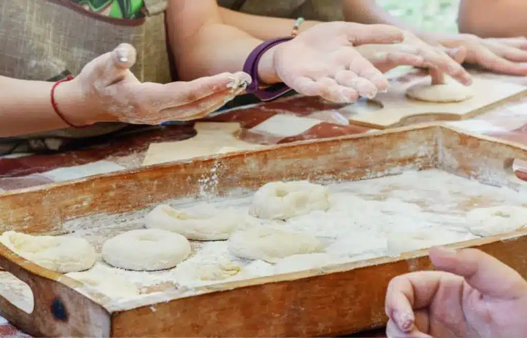 Children shaping homemade donut dough with their hands during a donut-making birthday party activity.