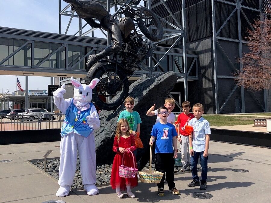 Group of children posing with the Easter Bunny outside the Harley-Davidson Museum in Milwaukee during a spring celebration.