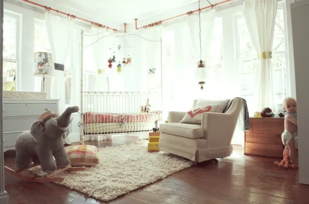 Elephant-inspired gender-neutral nursery with iron crib and sheer curtains