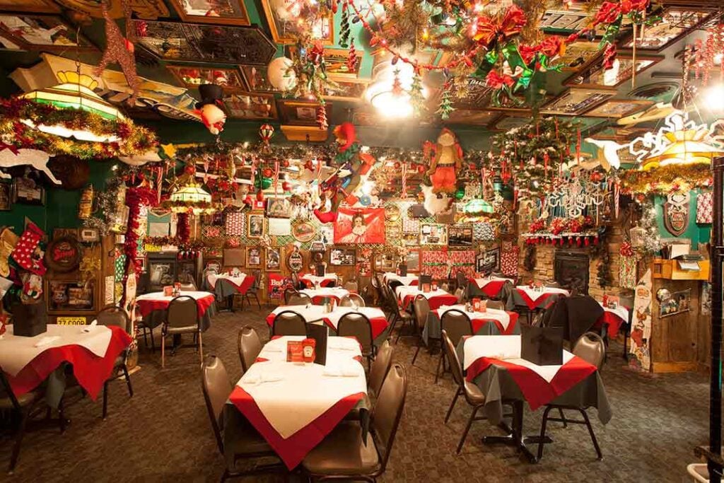 Restaurant interior decorated with various Christmas elements including  wreaths, garland and Santa
